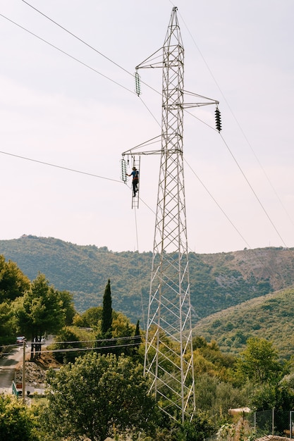 Electrician repairs an electrical support of a power line