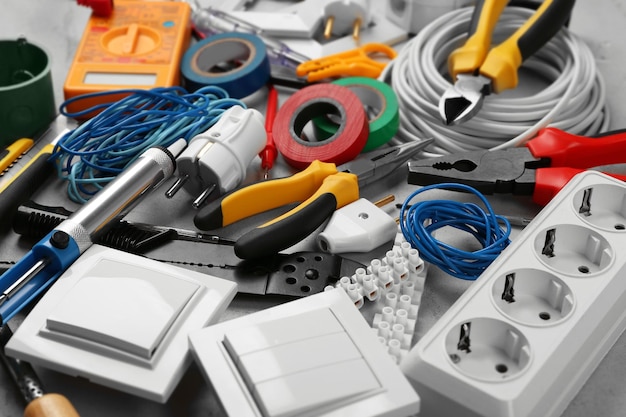 Electrician tools on grey background closeup