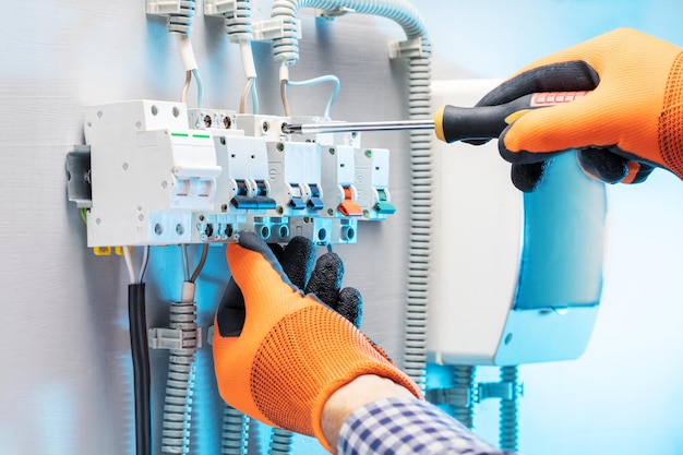 Electrician working at electric panel Technician is repairing the switchboard