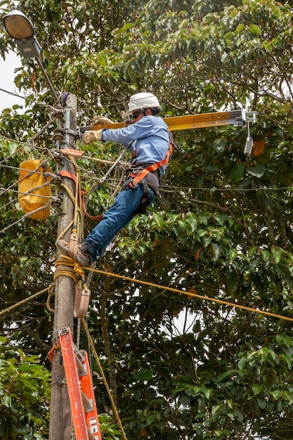 高電圧電気ケーブルの高所メンテナンスと修理で働く電気技師