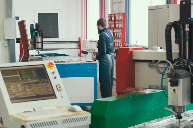 Electrician works with energy panel and machinery equipment on plant