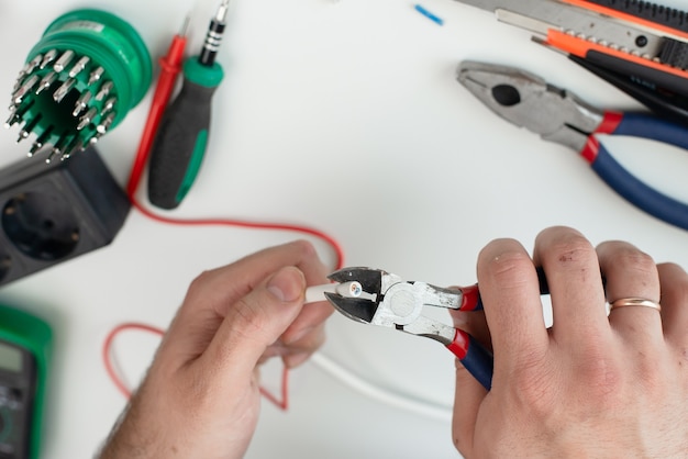 Electrician works with a tool. tools on white background