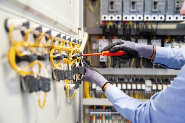 Electricians work to connect electric wires in the system\
switchboard electrical system