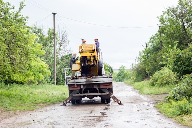 Electricians working on poles, a group of workers in special vehicles