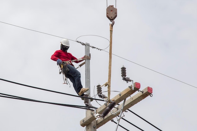 Photo electricians working on power pole connecting cables