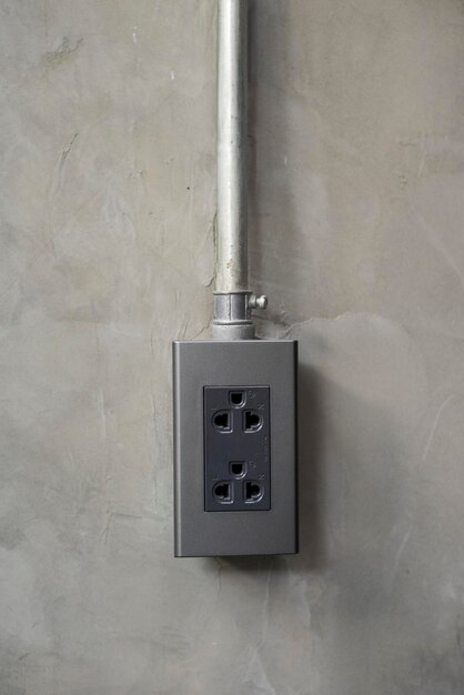 Electricity plug on industrial concrete wall background