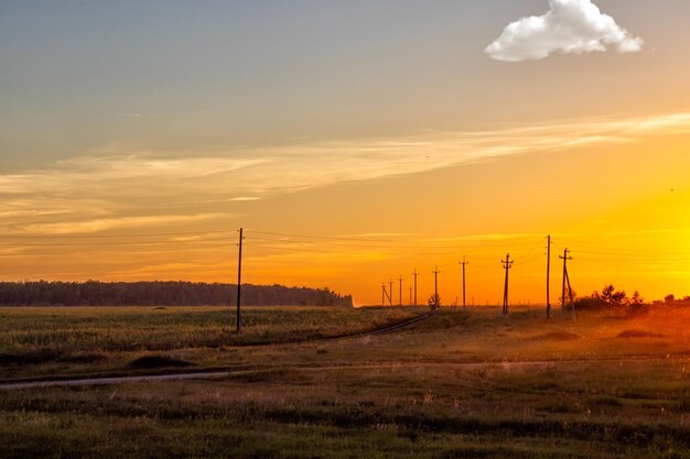 Electricity pylon on field against sky during sunset