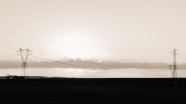 Electricity pylon on field against sky