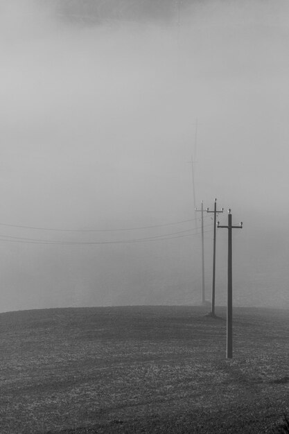 Electricity pylon on field against sky