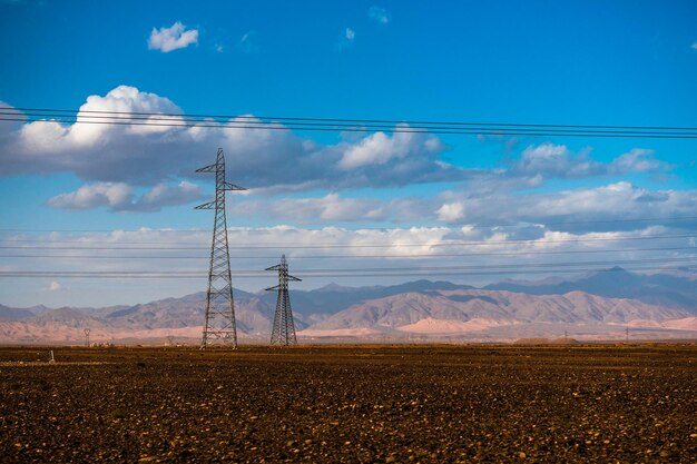 Electricity pylon on field against sky