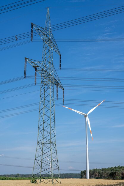 Electricity pylon wind turbine and power cables seen in germany