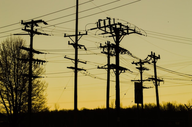 Foto pilastri elettrici contro il cielo giallo