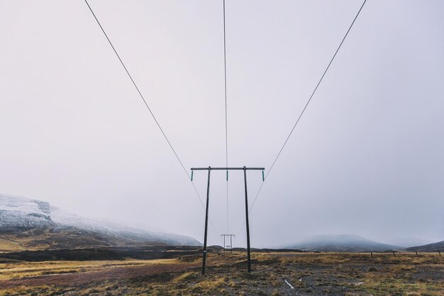 Foto pilastri elettrici sulla terra contro il cielo