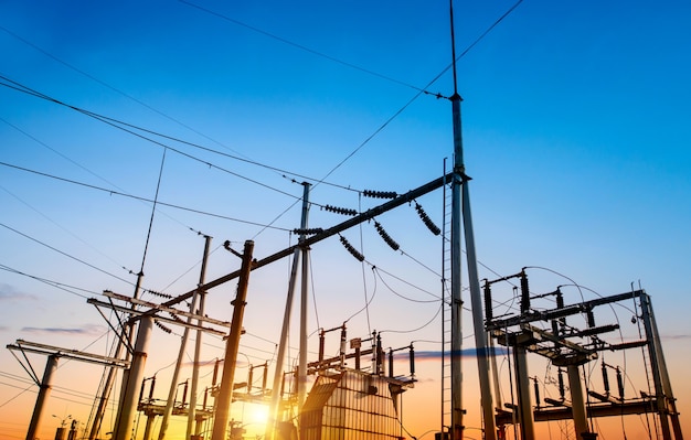 Electricity pylons at orange sunset