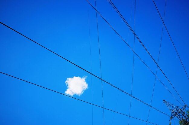 青い空の産業背景の電線