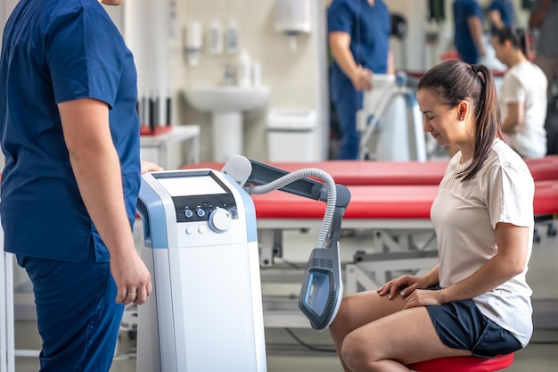 electromagnetic therapy of the knee joints physiotherapist doctor uses medical equipment for highly effective pain treatment and inflammation the magnetic field rehabilitation
