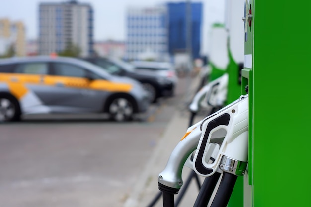 Фото Электронная зарядка для электромобиля зарядная станция для электромобилей в городе с автомобилями на заднем плане