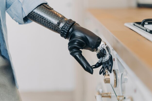 Electronic cyber hand of disabled person is switching a stove Sensor in fingers and wrist joint