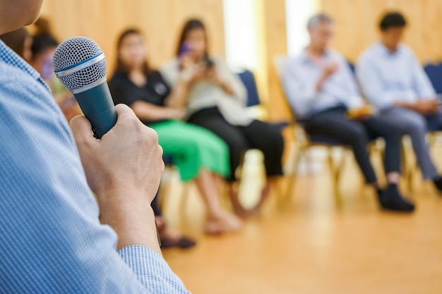 Electronic device on Asian Hand play social media in the meeting room with blur people behind