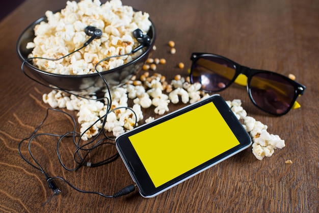 Foto smartphone dispositivo elettronico sullo sfondo del popcorn. copia spazio