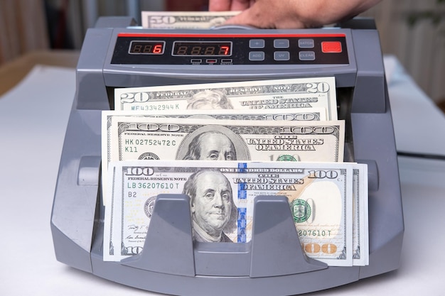 Electronic money counter machine is counting is counting the American dollar banknotes Finance and cash concept