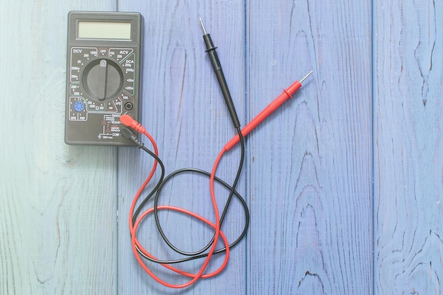 Foto multimetro elettronico per misurare la corrente su fondo di legno