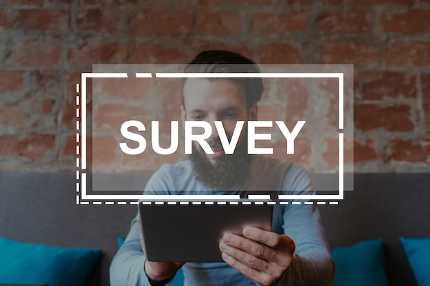 Electronic survey client experience product report happy male\
consumer answering questionnaire using tablet in loft interior with\
sign illustration