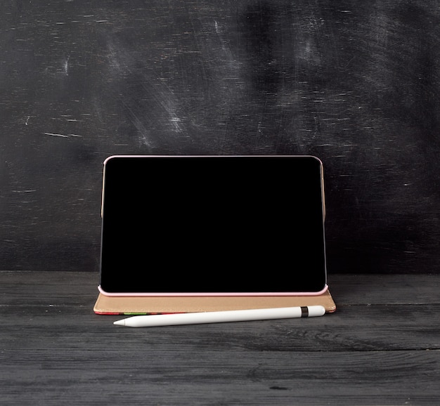 Electronic tablet with a blank black screen and white pencil