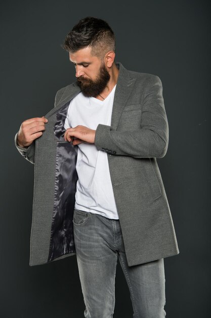 Elegance stays in fashion. Fashion guy grey background. Bearded man check pocket in jacket. Hipster with fashion look. Fashion and style. Casual business attire.