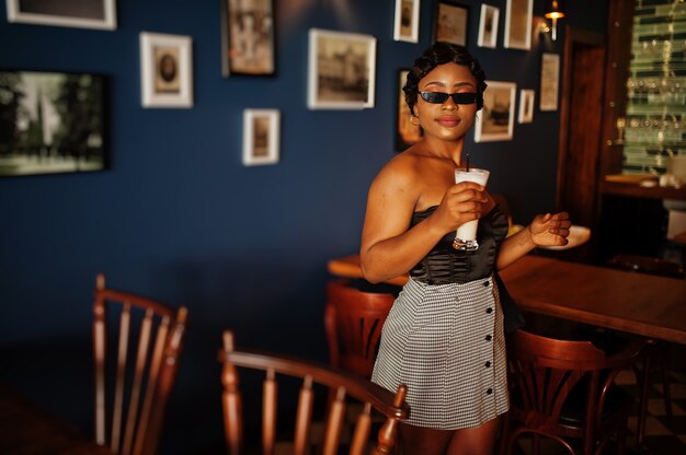 Foto elegante donna afro-americana in un bar