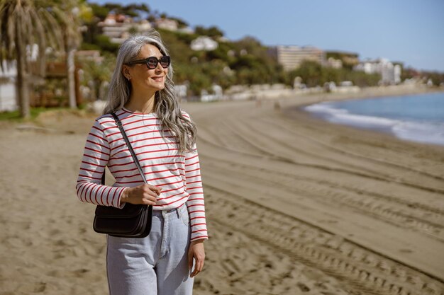 Elegant asian female standing outdoors by seafront