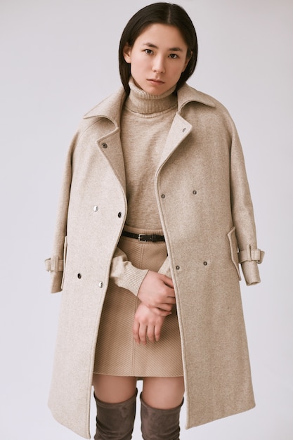 Элегантная азиатская женщина в модном шерстяном пальто и классической юбке