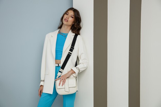 Elegant asian woman in white jacket blazer aqua blue top pants trousers accessories handbag