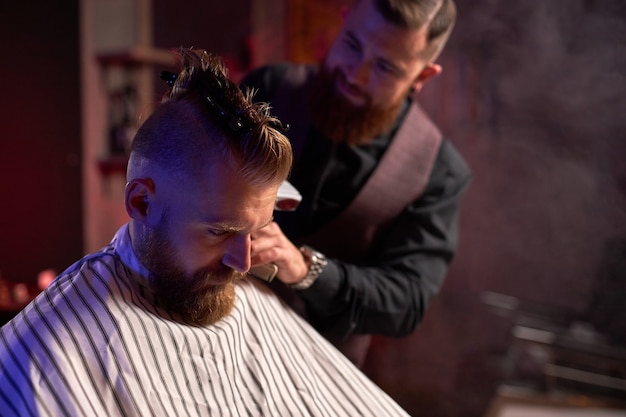 Elegant bearded businessman getting groomed at the hairdresser
