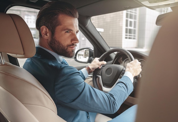 Elegant bearded male in suit traveling by automobile