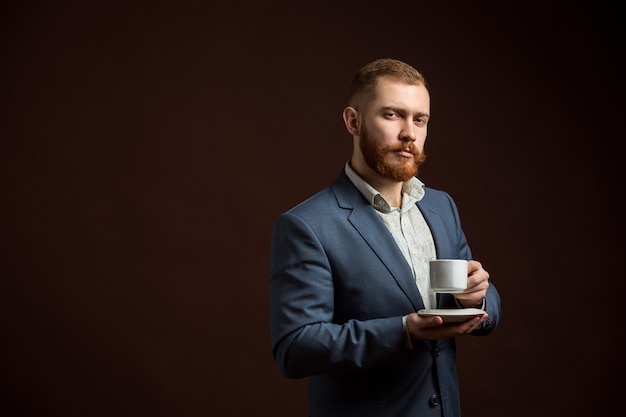 Elegant bearded man with cup of coffee