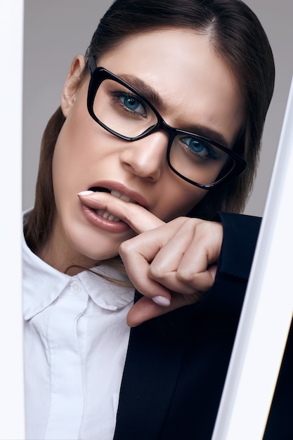 Elegant beautiful woman in a black fashionable suit and glasses