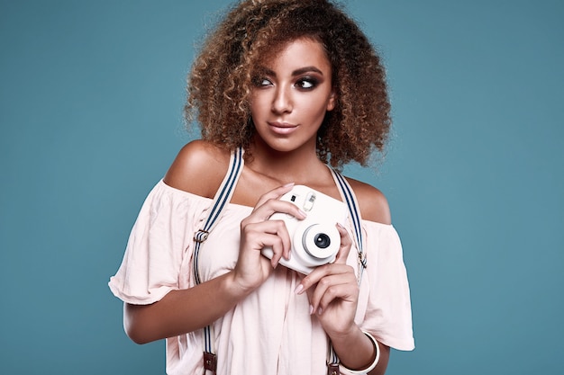 Elegant black woman model with curly hair and camera