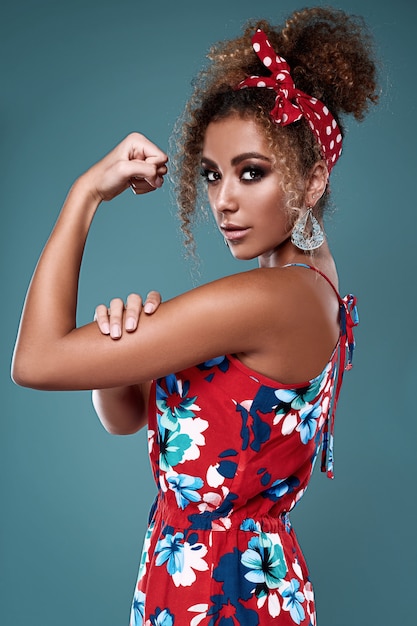 Elegant black woman model with curly hair in red dress