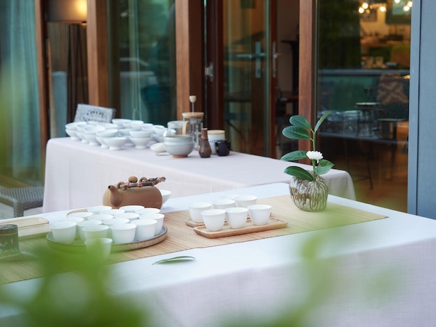 야외 차 서비스 찻주전자와 흰색 컵이 있는 이벤트 테이블에서의 우아한 휴식