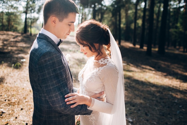 Elegant bride and groom posing together outdoors on a wedding day