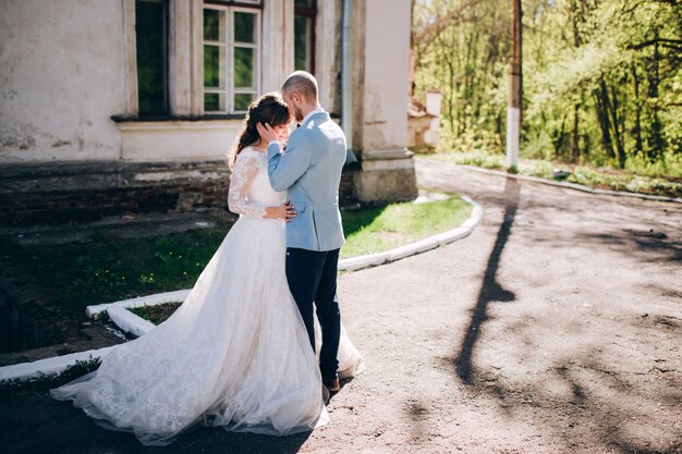 Foto elegante sposa e sposo che propongono insieme all'aperto in un giorno di nozze