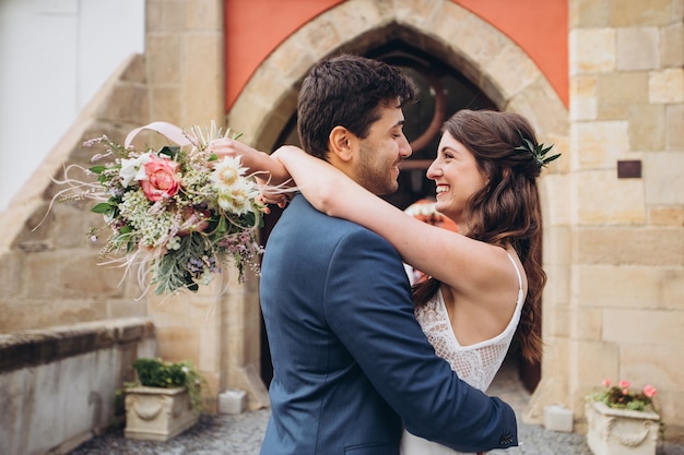 Foto elegante sposa e sposo che propongono insieme all'aperto