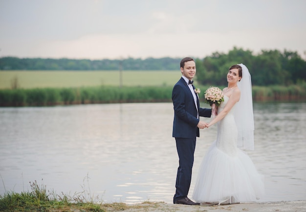 Elegant bride and groom posing together outdoors