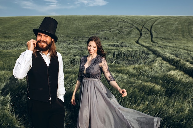 elegant bride and groom walking and posing on green field