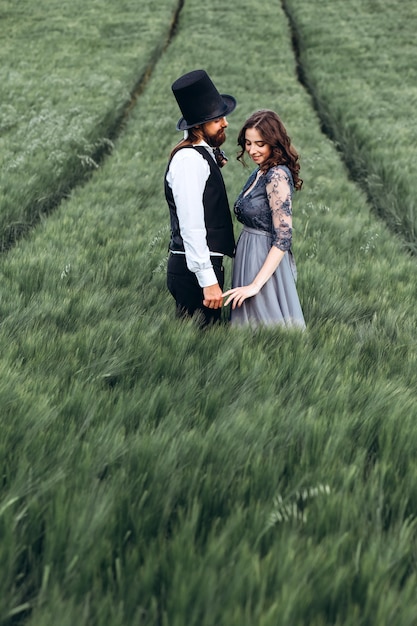 Elegant bride and groom walking and posing on green field