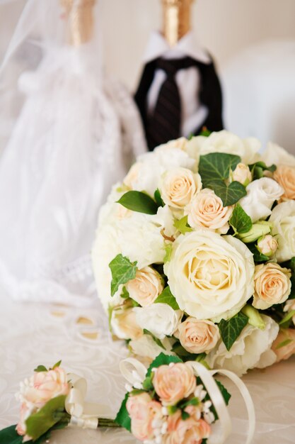 Elegant bruidsboeket en corsages van rozen van de bruidegom