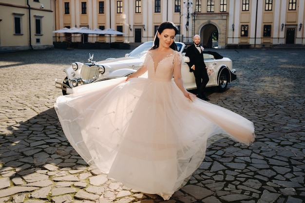 Elegant bruidspaar Op de binnenplaats van het kasteel bij een retro auto