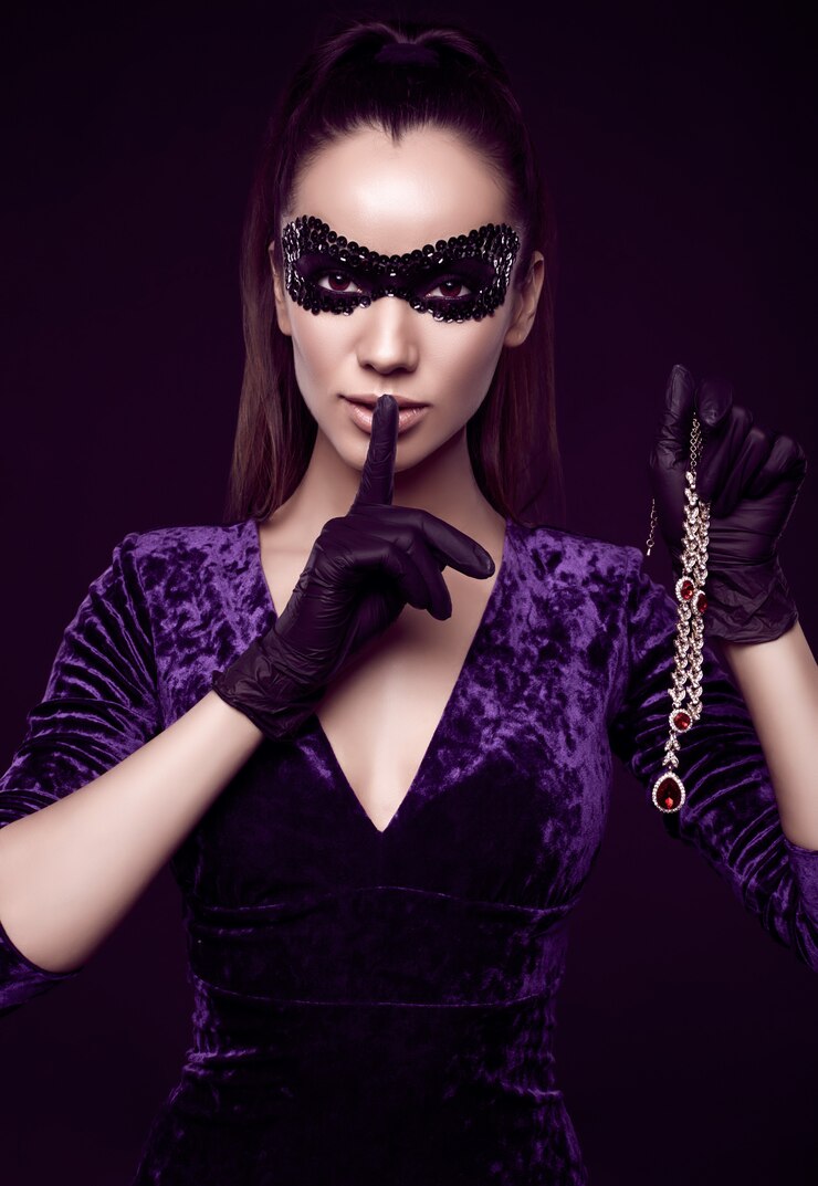 Elegant brunette woman in beautiful purple dress, sequins mask and black gloves