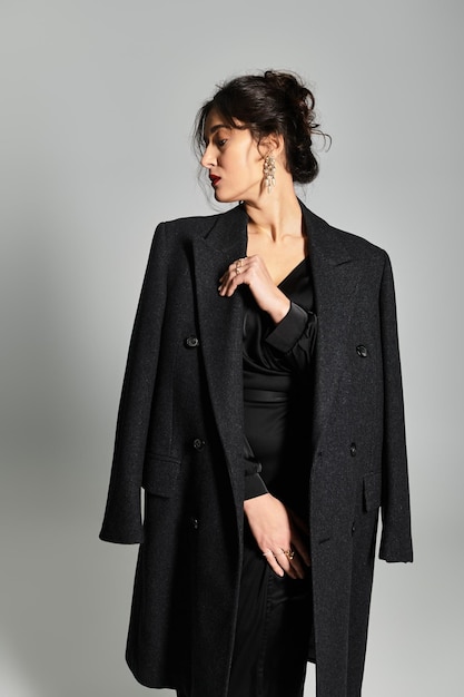 elegant brunette woman in sophisticated attire poses gracefully in studio setting